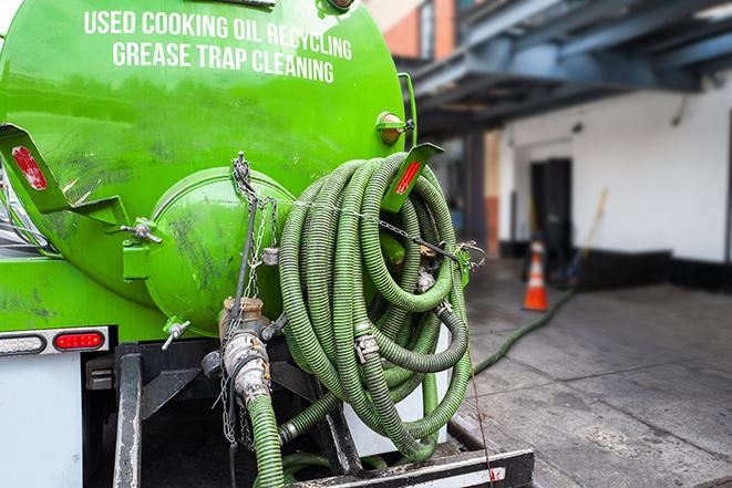 a technician pumping a grease trap in a commercial building in Wixom